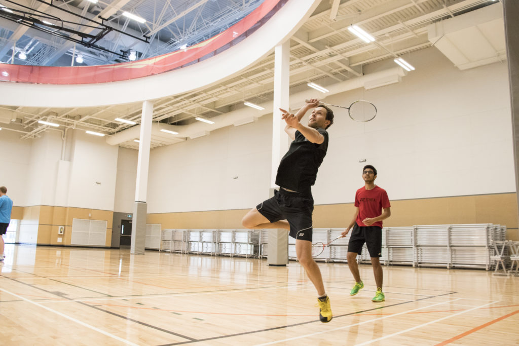 Two men playing badminton on the Sport Manitoba courts.